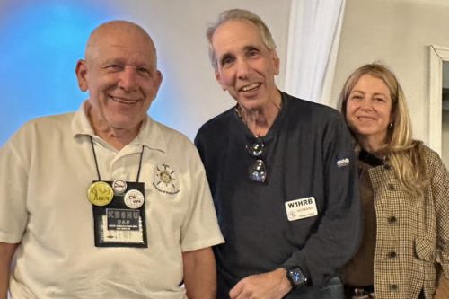 Two older men and a woman smiling at the camera.