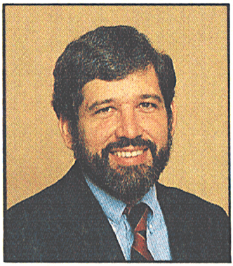 Head shot of young man with dark hair and a beard.